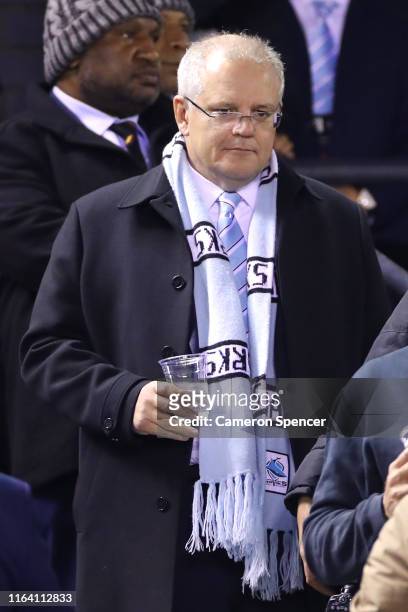 The Australian Prime Minister, Scott Morrison enjoys the atmosphere during the round 19 NRL match between the Cronulla Sharks and the North...