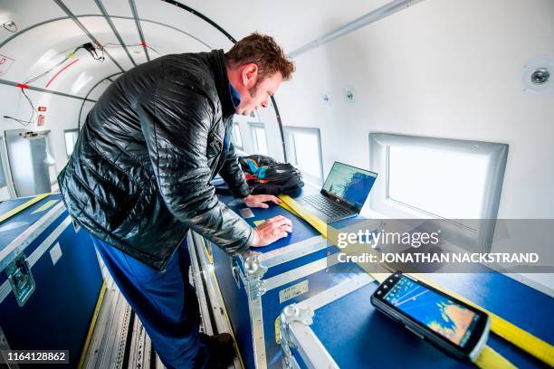 Joshua Willis, head of Oceans Melting Greenland, or OMG, prepares the equipment onboard the refitted DC3, built in 1942 for the Canadian air force...