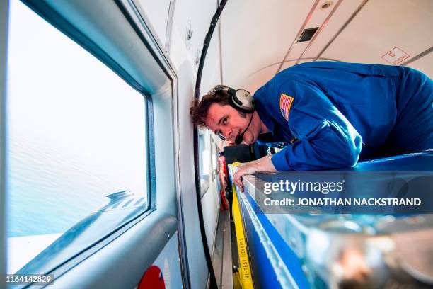 Joshua Willis, head of Oceans Melting Greenland, or OMG, watches after dropping a 1.5-metre cylindrical probe from onboard the refitted DC3, built in...