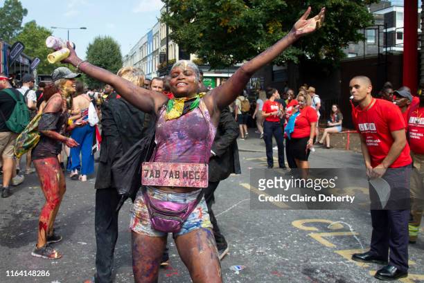 Party goers take part in the traditional J'ouvert opening parade of the Notting Hill Carnival, where paint is thrown and they cover each other in...