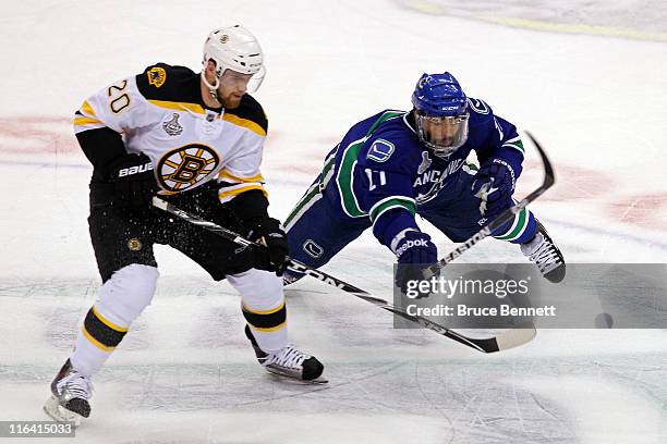 Manny Malhotra of the Vancouver Canucks falls to the ice after colliding with Daniel Paille of the Boston Bruins during Game Seven of the 2011 NHL...