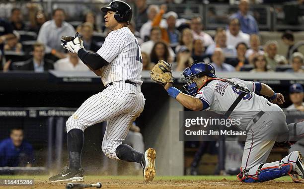 Alex Rodriguez of the New York Yankees scores a fifth inning run ahead of the tag from Yorvit Torrealba of the Texas Rangers on June 15, 2011 at...