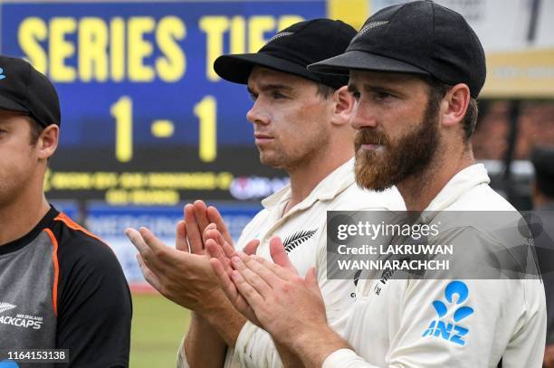 Zealand's cricket team captain Kane Williamson and teammate Tom Latham applaud during the presentation ceremony on the final day of the final cricket...