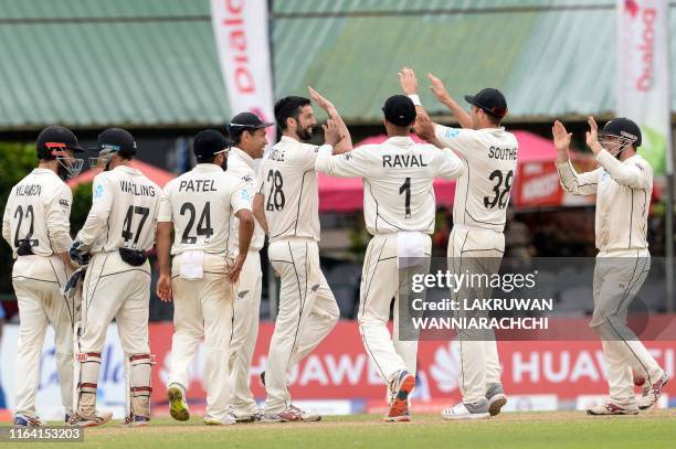 New Zealand cricketers William Somerville celebrates with his teammates after he dismissed Sri Lanka's cricketer Suranga Lakmal during the final day...