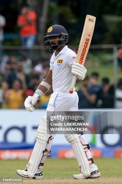 Sri Lanka's cricketer Niroshan Dickwella raises his bat to the crowd after scoring a half-century during the final day of the final cricket Test...