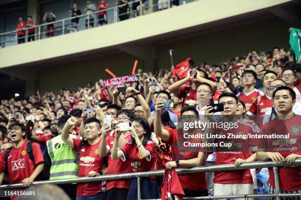 Manchester United supporters cheer after the International Champions Cup match between Tottenham Hotspur and Manchester United at the Shanghai...