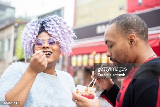 viajantes millennial que tentam iguarias locais - takoyaki - fotografias e filmes do acervo