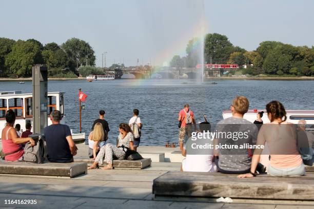 August 2019, Hamburg: In the afternoon, numerous people sit at temperatures above 30 degrees Celsius on the Binnenalster and look at the Alster...