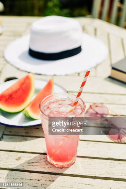 summer in the garden, glass of iced pink lemonade outdoors on a garden table. - watermelon picnic stock pictures, royalty-free photos & images