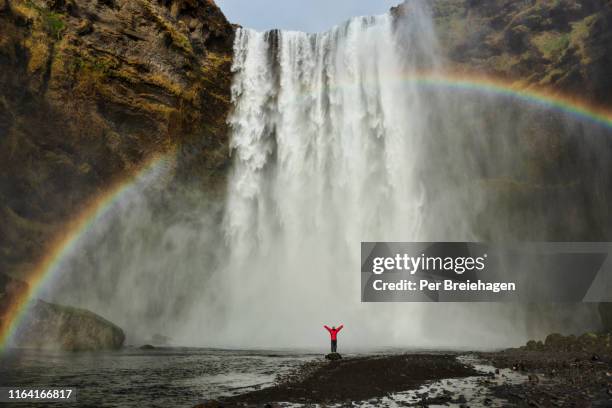 a rainbow and a girl at skogafoss_iceland - waterfall photos et images de collection