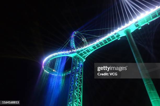 Aerial view of a circular glass bridge at the Huangtengxia tourist attraction on July 23, 2019 in Qingyuan, Guangdong Province of China. Dozens of...