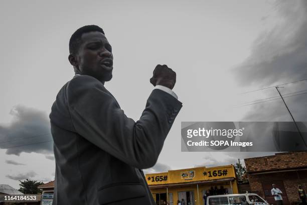 Bobi Wine waves to supporters during a campaign event in Gombe. Bobi Wine, whose real name is Robert Kyagulanyi, a popstar and opposition leader...