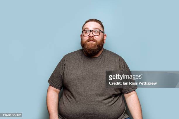 overweight bearded hipster on blue background - dicke menschen stock-fotos und bilder