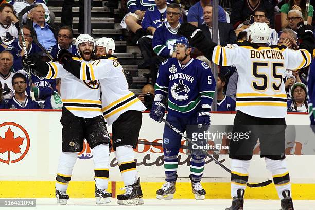 Patrice Bergeron of the Boston Bruins celebrates with Gregory Campbell and Johnny Boychuk after he scored the 3rd goal in the second period against...