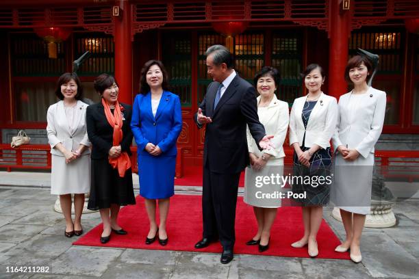 Chinese Foreign Minister Wang Yi gestures after a group photo with Seiko Noda , team leader and other members of the China-Japan Friendship female...