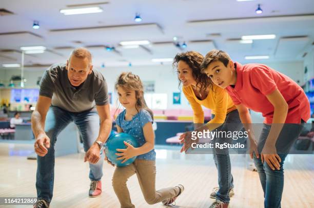 mädchen bowling mit familie - family bowling stock-fotos und bilder