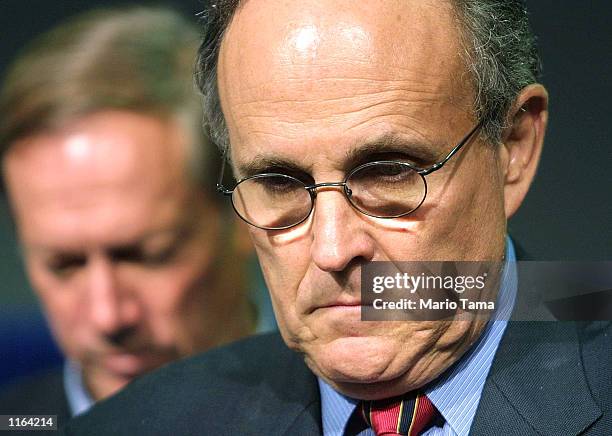 New York City Mayor Rudy Giuliani and Governor George Pataki bow their heads in prayer at the beginning of a press conference September 19, 2001 in...