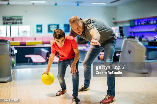 mann und sein sohn beim bowling - family bowling stock-fotos und bilder