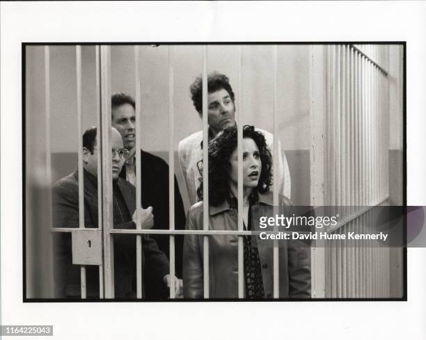 Left to right, actors Jason Alexander , Jerry Seinfeld , Michael Richards , and Julia Louis-Dreyfus stand behind bars in a scene during the last days...