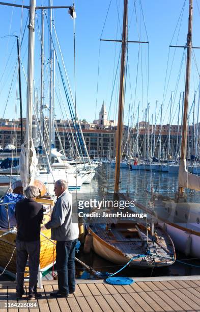 marseille, france: two senior men chat at old port/vieux port - old port stock pictures, royalty-free photos & images