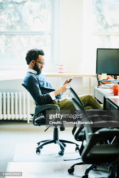 businessman working on smartphone at workstation in office - findlater stock pictures, royalty-free photos & images