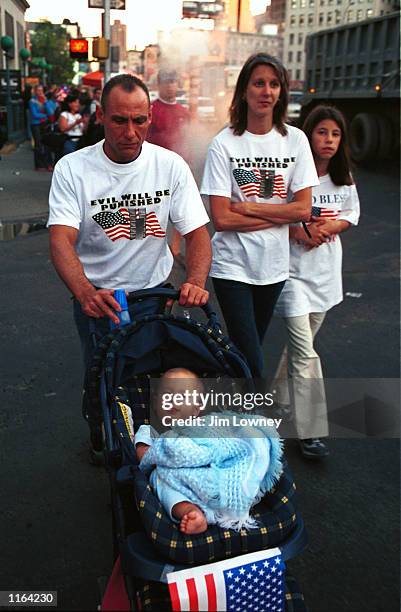 Family walks along the police lines on Canal Street wearing shirts that read "Evil Will Be Punished" September 15, 2001 in New York City four days...