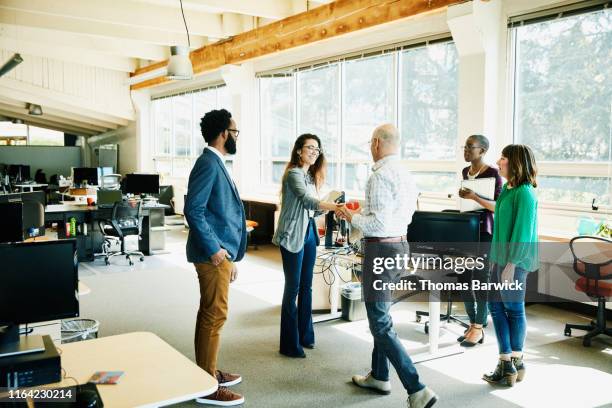 businesswoman shaking hands with client before meeting in start up office - arrival stockfoto's en -beelden