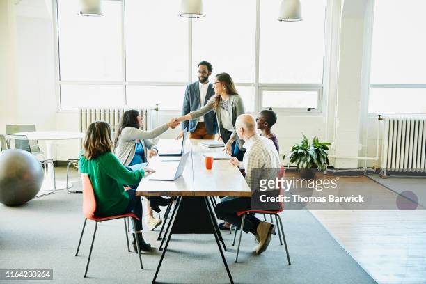 businesswoman shaking hands with client during meeting in office conference room - handshake concept stock pictures, royalty-free photos & images