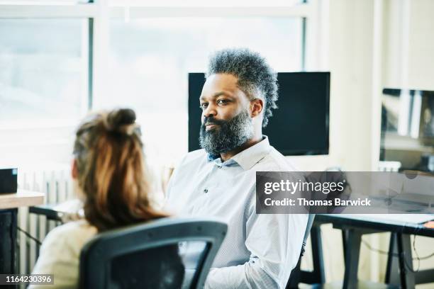 businessman discussing project with colleagues in high tech office - estilo de peinado de sumo fotografías e imágenes de stock