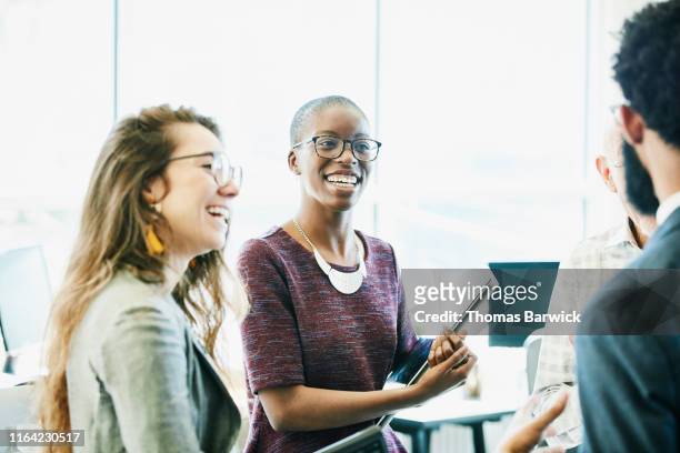 smiling business colleagues in discussion during informal meeting in start up office - group people thinking stock pictures, royalty-free photos & images