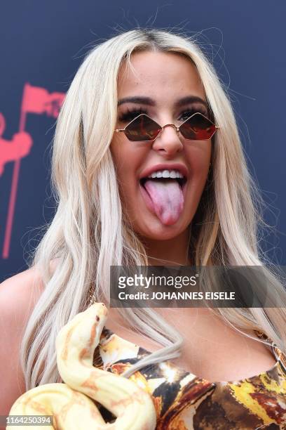 Internet personality Tana Mongeau holds a snake as she arrives for the 2019 MTV Video Music Awards at the Prudential Center in Newark, New Jersey on...