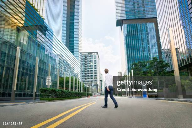 rear view of businessman in modern city - fugitive stock-fotos und bilder