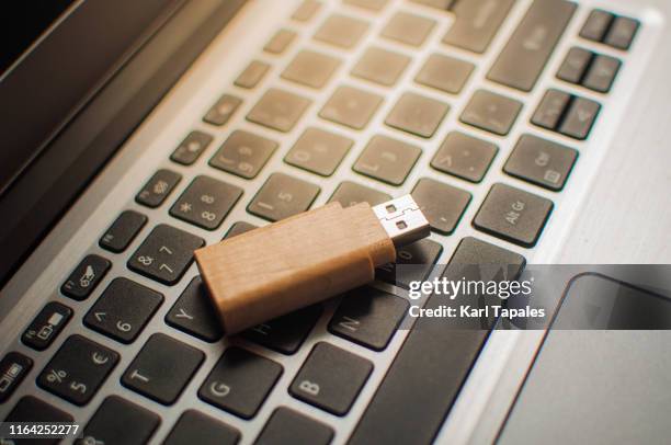 a close-up view of usb stick on a laptop keyboard - hard drive stock pictures, royalty-free photos & images