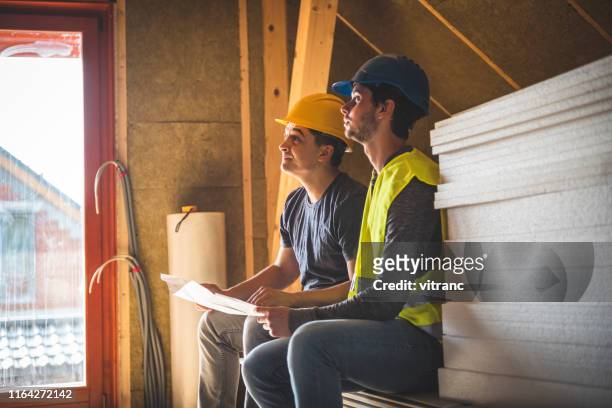 construction worker and engineer at the construction site - house insulation not posing stock pictures, royalty-free photos & images