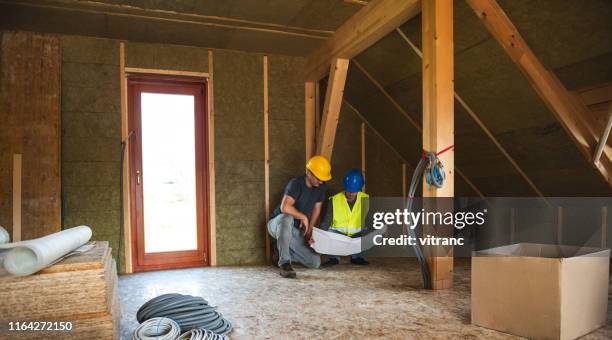 construction worker and engineer at the construction site - attic stock pictures, royalty-free photos & images