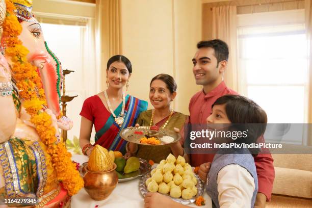 family perfoming ganpati aarti on ganesh chaturthi at home - arctis stock pictures, royalty-free photos & images