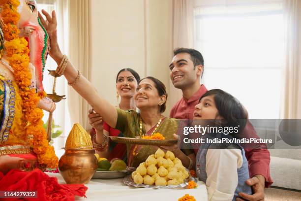 family perfoming ganpati aarti on ganesh chaturthi at home - ganesh chaturthi fotografías e imágenes de stock