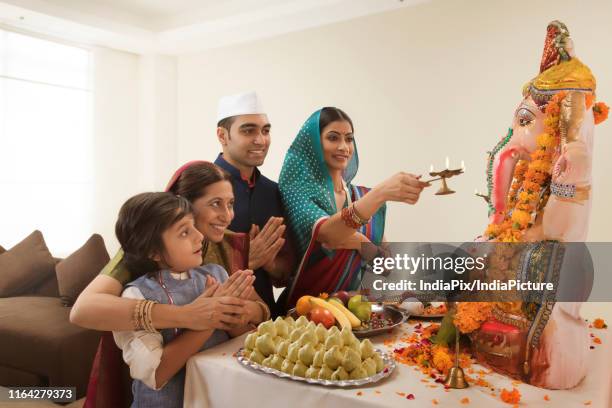 family praying on ganesh chaturthi where grandmother teaches grandson how to pray. - arctis stock pictures, royalty-free photos & images