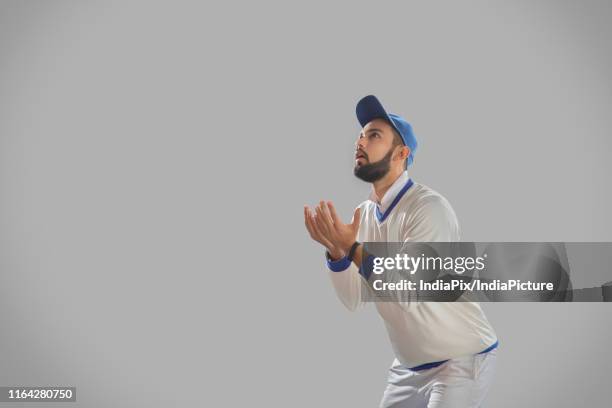 fielder waiting to catch a ball on grey background - man catching stock pictures, royalty-free photos & images