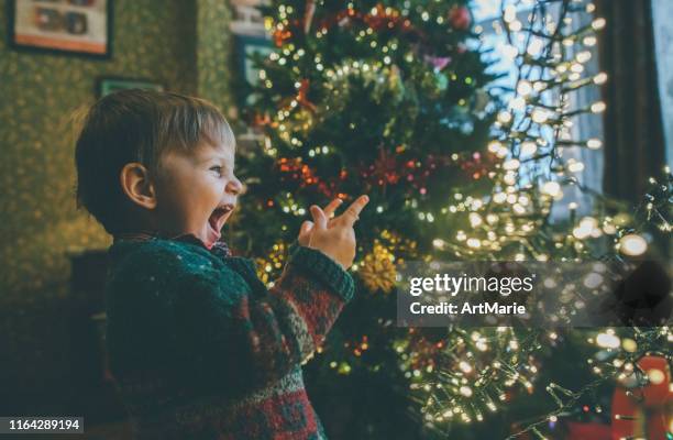 家でクリスマスライトで遊ぶ小さな男の子 - children christmas ストックフォトと画像