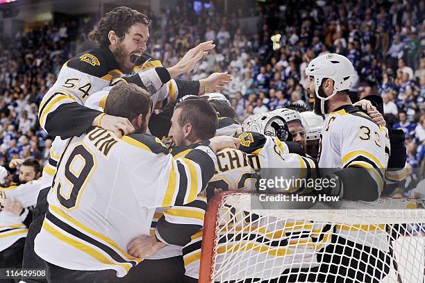 Adam McQuaid of the Boston Bruins celebrates with his teammates Brad Marchand, Tyler Seguin, Tim Thomas and Zdeno Chara after defeating the Vancouver...