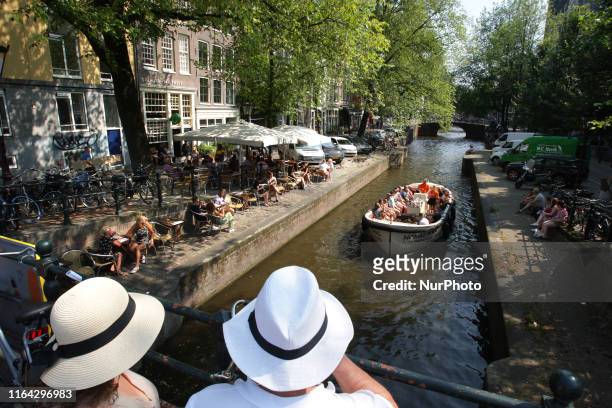 Tourists and locals enjoying at the Leligracht canal during today's afternoon with a temperature of 30 degrees Celsius on August 26, 2019 in...