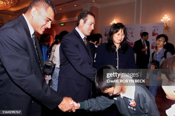 Local mini-rugby player performs a bow fit for royalty as he is introduced to Eric Rush of New Zealand and David Campese of Australia 25 January at...