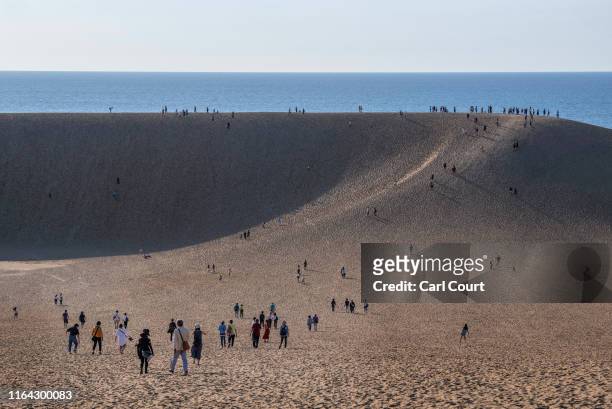 Tourists visit Tottori Sand Dunes on August 26, 2019 in Tottori, Japan. The Tottori Sand Dunes form the only large dune system in Japan and were...