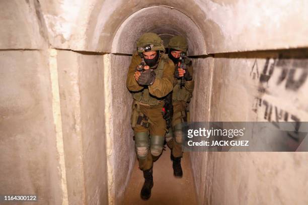 Israeli soldiers engage in combat exercise inside a physical mockup enemy tunnel at an Israeli Army base in Petah Tikva, northeast of Tel Aviv, on...