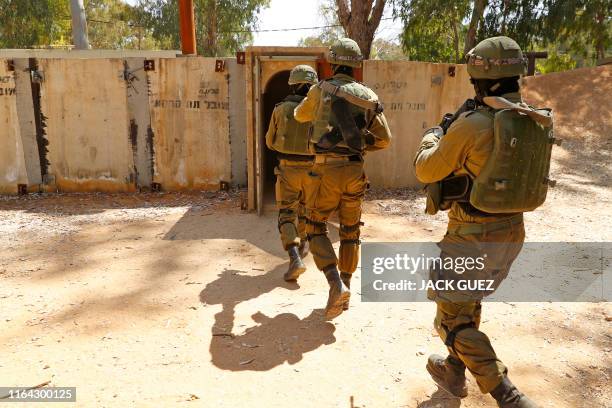 Israeli soldiers enter a physical mockup enemy tunnel, to take part in combat exercise, at an Israeli Army base in Petah Tikva, northeast of Tel...