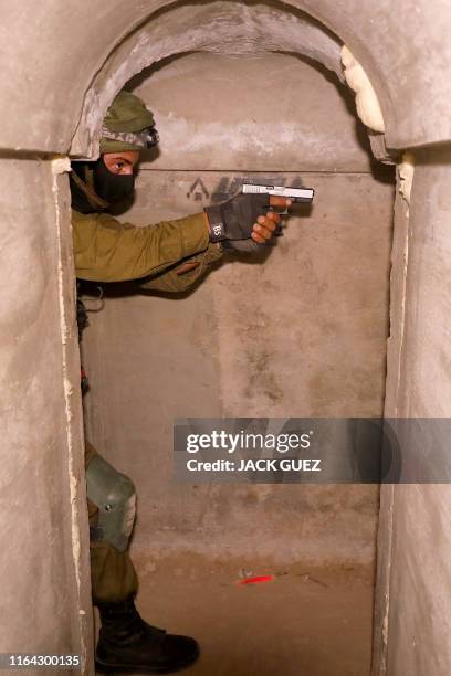 An Israeli soldier engages in combat exercise inside a physical mockup enemy tunnel at an Israeli Army base in Petah Tikva, northeast of Tel Aviv, on...