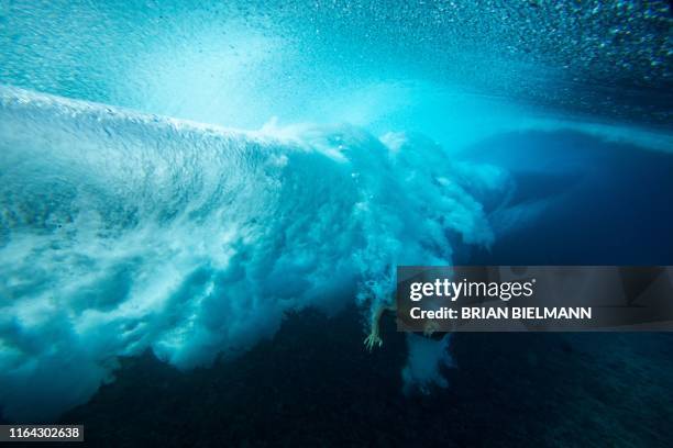 Surfer takes a wipeout on August 24 in Teahupoo, Tahiti, during a freesurf session at the 2019 Tahiti Pro event. / RESTRICTED TO EDITORIAL USE