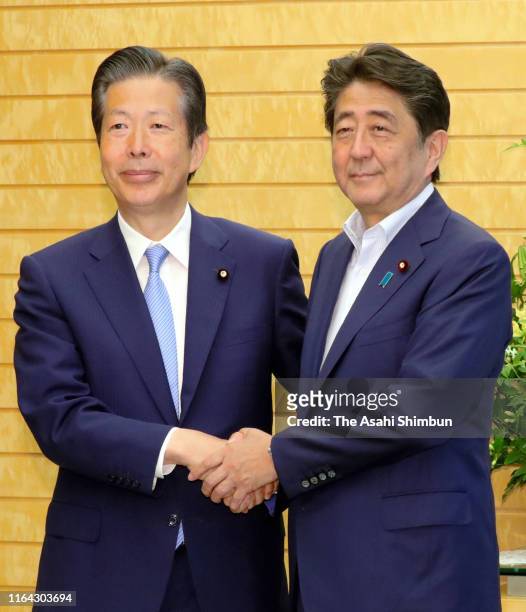 Prime Minister and ruling Liberal Democratic Party President Shinzo Abe and its junior coalition Komeito leader Natsuo Yamaguchi shake hands prior to...