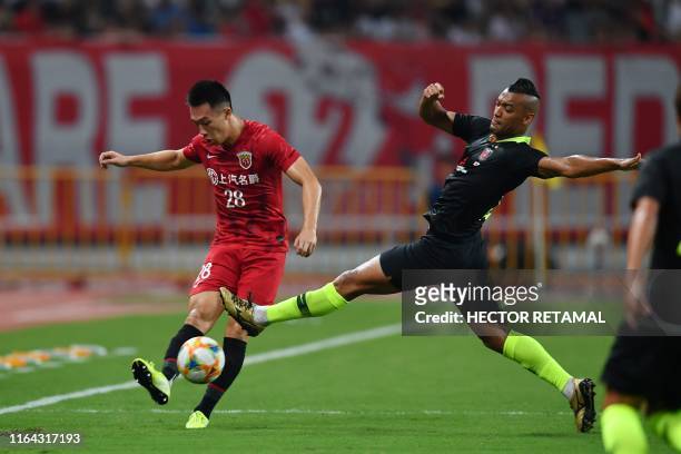 Shanghai SIPG's Guan He fights for the ball with Urawa Red Diamonds's Fabricio Dos Santos during their AFC Champions League quarter-final football...